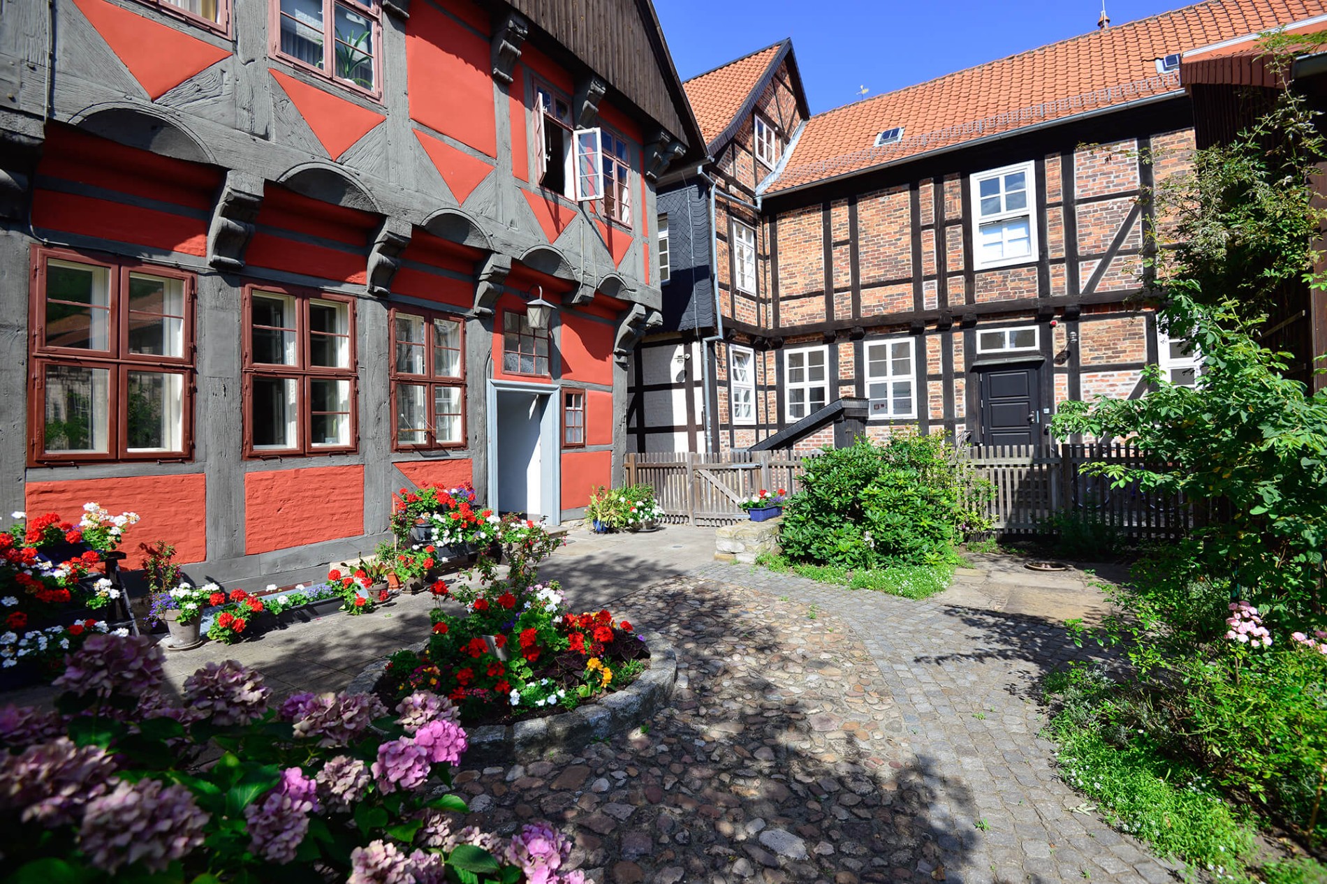 Innenhof des Kavalierhauses mit rot-grauem Fachwerk mit Garten in der Gifhorner Altstadt